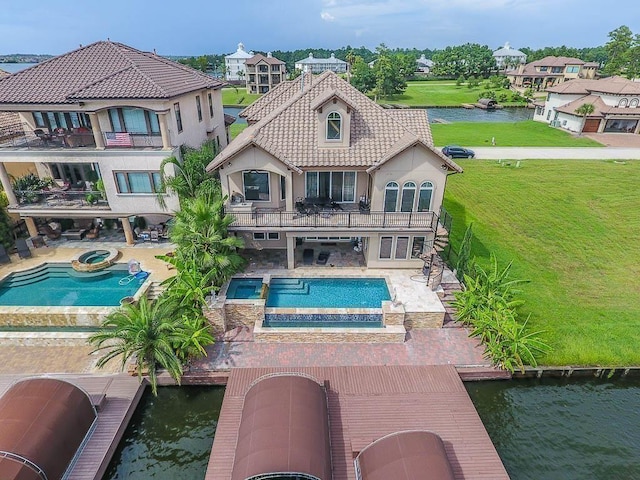 12349 Tramonto Dr, Conroe, TX 77304 - rear view of property with a balcony, a pool with connected hot tub, a water view, stucco siding, and a patio area