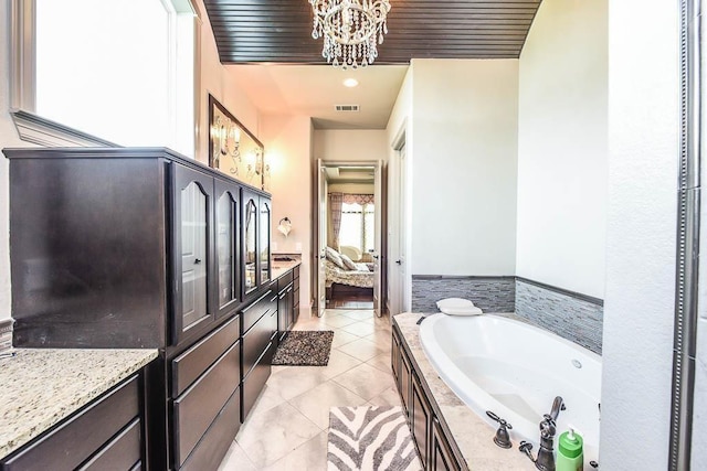 12349 Tramonto Dr, Conroe, TX 77304 - ensuite bathroom featuring a garden tub, a chandelier, and tile patterned floors