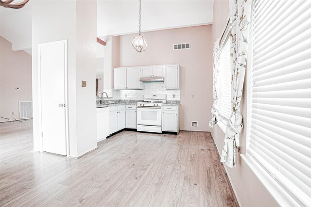 1103 W Brompton Dr, Pearland, TX 77584 - kitchen with white appliances, under cabinet range hood, a towering ceiling, light wood-style floors, and a chandelier