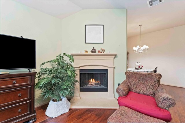 18843 Cove Pointe Dr, Cypress, TX 77433 - living room featuring wood finished floors, a warm lit fireplace, a chandelier, and lofted ceiling