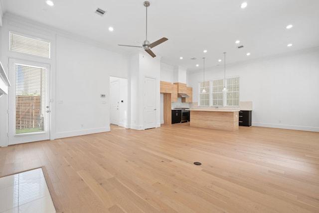 614 Delmar St, Houston, TX 77023 - unfurnished living room featuring light wood-style flooring, ceiling fan, recessed lighting, and crown molding