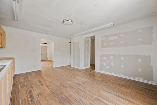 3822 Wipprecht St, Houston, TX 77026 - unfurnished living room with arched walkways and light wood-style floors