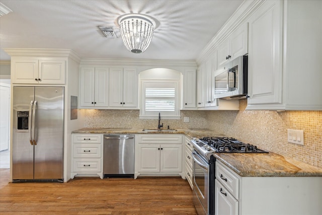 1710 Gardenia Dr, Houston, TX 77018 - kitchen featuring stainless steel appliances, white cabinetry, light stone counters, and decorative backsplash