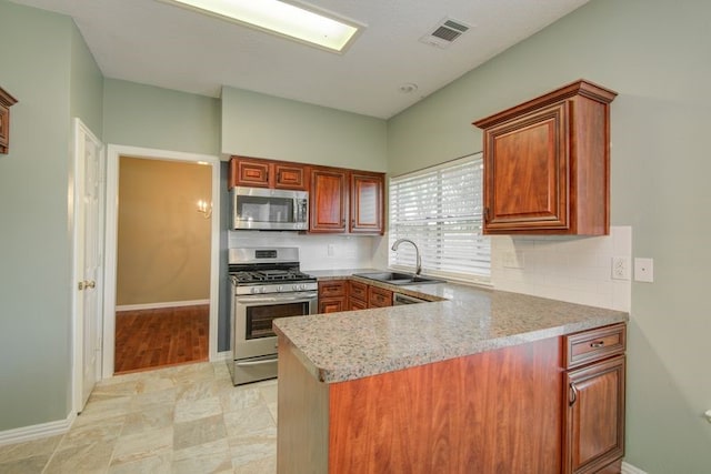 2917 Veva Dr, Pearland, TX 77584 - kitchen featuring appliances with stainless steel finishes, a peninsula, light countertops, and decorative backsplash