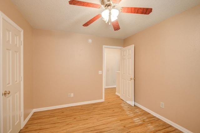 2917 Veva Dr, Pearland, TX 77584 - unfurnished bedroom featuring light wood-style floors, a textured ceiling, and ceiling fan