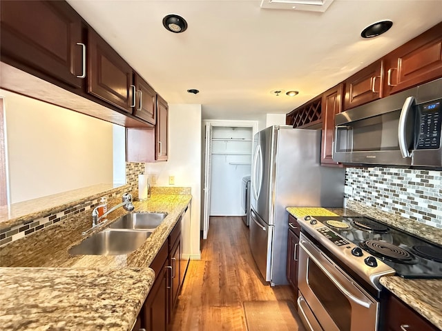 3525 Sage Rd Unit 1204, Houston, TX 77056 - kitchen featuring appliances with stainless steel finishes, decorative backsplash, wood finished floors, light stone countertops, and recessed lighting
