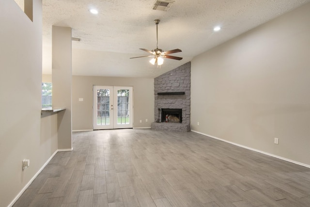 16822 Applecross Ln, Houston, TX 77084 - unfurnished living room featuring a textured ceiling, a ceiling fan, wood finished floors, lofted ceiling, and a stone fireplace