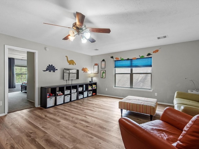 13923 Roanoke Falls Dr, Cypress, TX 77429 - living room featuring wood finished floors, a ceiling fan, and a textured ceiling