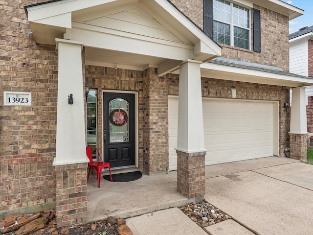 13923 Roanoke Falls Dr, Cypress, TX 77429 - view of exterior entry with brick siding, a garage, and driveway