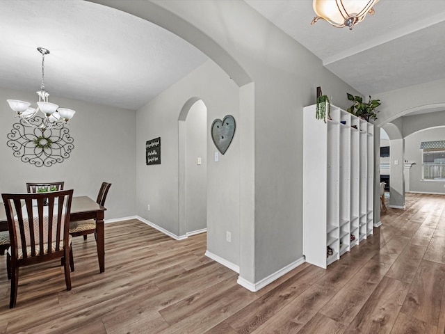 13923 Roanoke Falls Dr, Cypress, TX 77429 - dining area with wood finished floors, arched walkways, and a chandelier