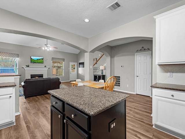 13923 Roanoke Falls Dr, Cypress, TX 77429 - kitchen with arched walkways, ceiling fan, white cabinets, light wood-type flooring, and recessed lighting