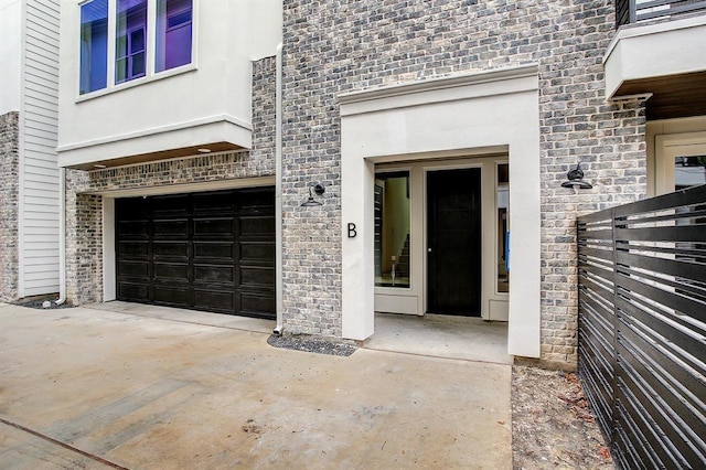 1405 Indiana St Unit B, Houston, TX 77006 - property entrance with an attached garage, stone siding, stucco siding, and driveway