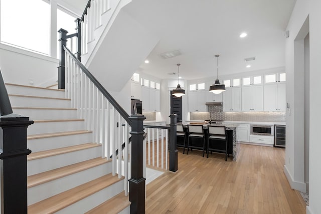 1405 Indiana St Unit B, Houston, TX 77006 - staircase featuring wine cooler, wood-type flooring, and recessed lighting