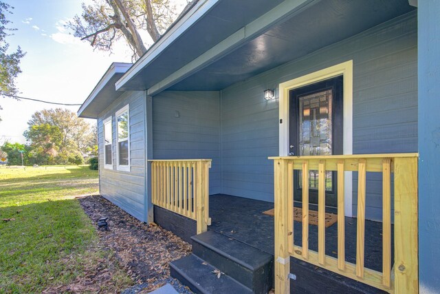 1111 Robinson St, Alvin, TX 77511 - entrance to property with a yard, a wooden deck, and covered porch