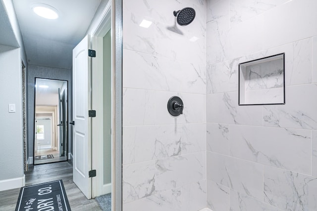 1111 Robinson St, Alvin, TX 77511 - bathroom with tiled shower and wood finished floors