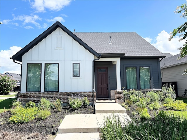 18518 Parkland Xing, Cypress, TX 77433 - view of front facade with board and batten siding, roof with shingles, and brick siding