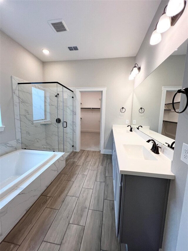 18518 Parkland Xing, Cypress, TX 77433 - full bath featuring a stall shower, a garden tub, double vanity, a spacious closet, and wood finished floors