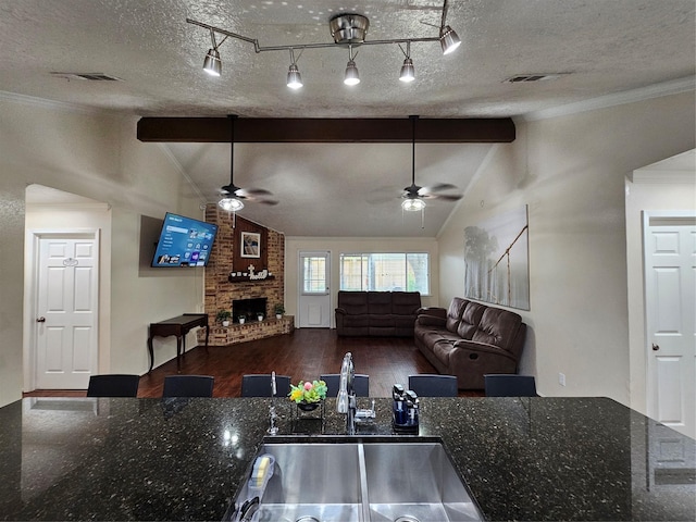 19423 Quiet Brook Dr, Houston, TX 77084 - kitchen featuring a ceiling fan, wood finished floors, a fireplace, ornamental molding, and a textured ceiling