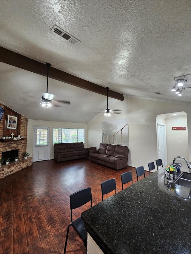 19423 Quiet Brook Dr, Houston, TX 77084 - dining room with ceiling fan, dark wood-style floors, a textured ceiling, a fireplace, and arched walkways