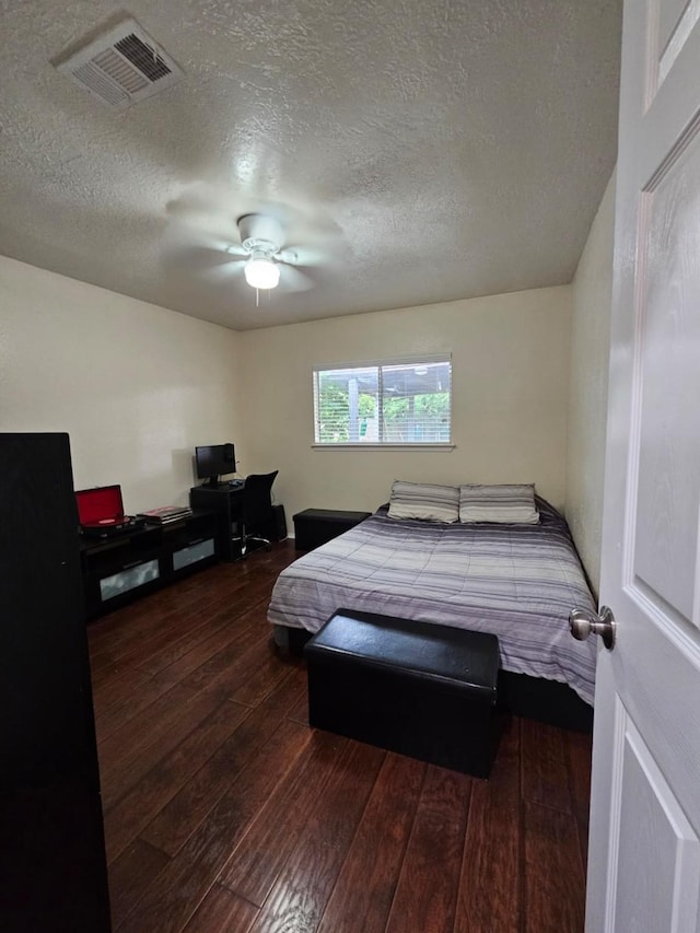 19423 Quiet Brook Dr, Houston, TX 77084 - bedroom featuring dark wood-style flooring, an office area, a textured ceiling, and a ceiling fan