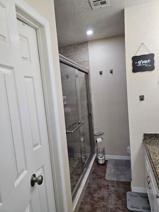 19423 Quiet Brook Dr, Houston, TX 77084 - bathroom featuring vanity, a shower stall, a textured ceiling, and a textured wall