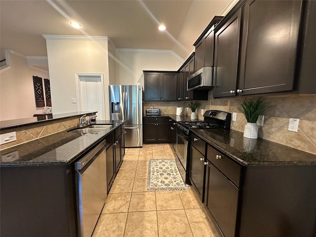 6818 Pear Point Ln, Richmond, TX 77469 - kitchen featuring crown molding, stainless steel appliances, dark stone countertops, decorative backsplash, and a kitchen island with sink