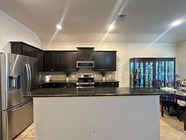 6818 Pear Point Ln, Richmond, TX 77469 - kitchen featuring stainless steel appliances, crown molding, backsplash, dark stone countertops, and a kitchen island