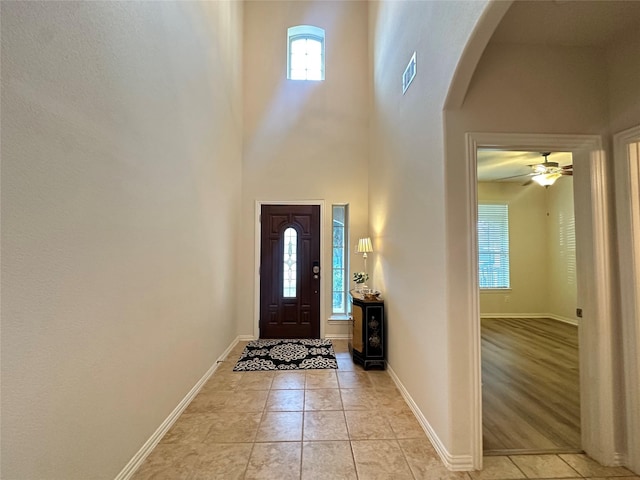 6818 Pear Point Ln, Richmond, TX 77469 - foyer entrance with arched walkways, light tile patterned flooring, a high ceiling, and ceiling fan