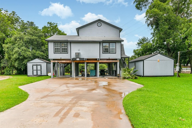7806 Burgess Rd, Hitchcock, TX 77563 - back of property featuring a storage unit, a carport, a lawn, and concrete driveway