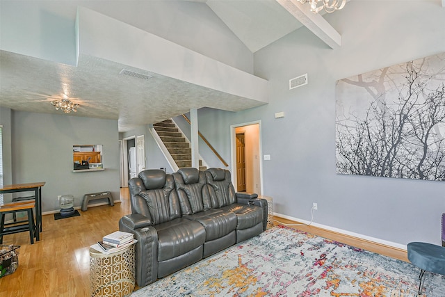 7806 Burgess Rd, Hitchcock, TX 77563 - living room featuring wood finished floors, stairs, high vaulted ceiling, and a chandelier