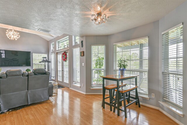 7806 Burgess Rd, Hitchcock, TX 77563 - dining space featuring a textured ceiling, wood finished floors, a chandelier, and vaulted ceiling