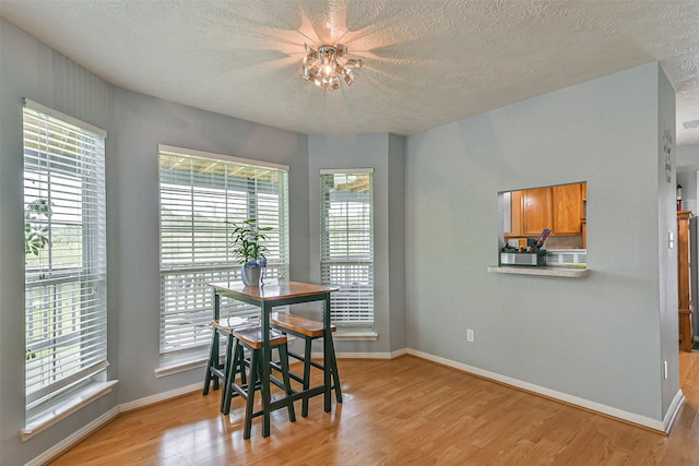 7806 Burgess Rd, Hitchcock, TX 77563 - dining room featuring light wood-type flooring and a textured ceiling