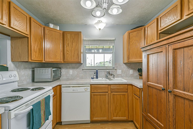 7806 Burgess Rd, Hitchcock, TX 77563 - kitchen featuring white appliances, light countertops, a textured ceiling, light wood finished floors, and a chandelier