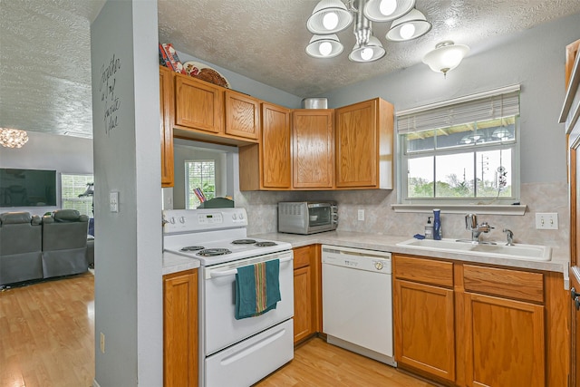 7806 Burgess Rd, Hitchcock, TX 77563 - kitchen featuring a chandelier, white appliances, a textured ceiling, light wood finished floors, and light countertops