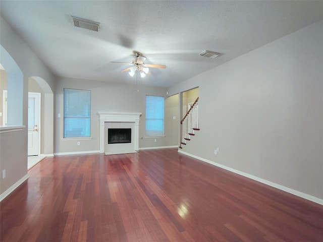 3511 Glenhill Dr, Pearland, TX 77584 - unfurnished living room with ceiling fan, wood finished floors, a fireplace with flush hearth, and arched walkways