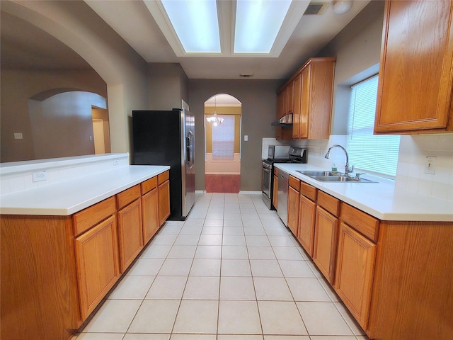 3511 Glenhill Dr, Pearland, TX 77584 - kitchen with arched walkways, appliances with stainless steel finishes, light countertops, and brown cabinets
