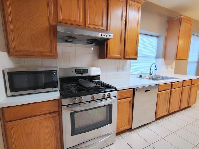 3511 Glenhill Dr, Pearland, TX 77584 - kitchen with appliances with stainless steel finishes, under cabinet range hood, light countertops, backsplash, and light tile patterned flooring