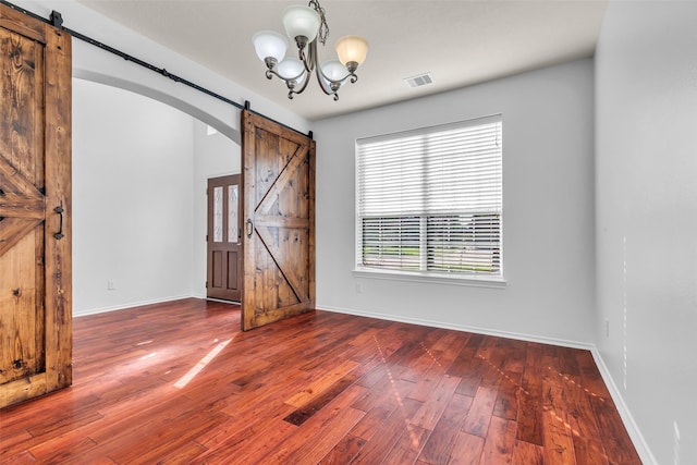 3502 Avalon Spring Ln, Spring, TX 77386 - unfurnished dining area with a barn door, hardwood / wood-style flooring, a chandelier, and arched walkways