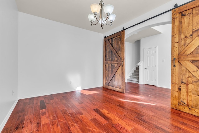 3502 Avalon Spring Ln, Spring, TX 77386 - unfurnished dining area featuring a barn door, wood finished floors, arched walkways, and a chandelier