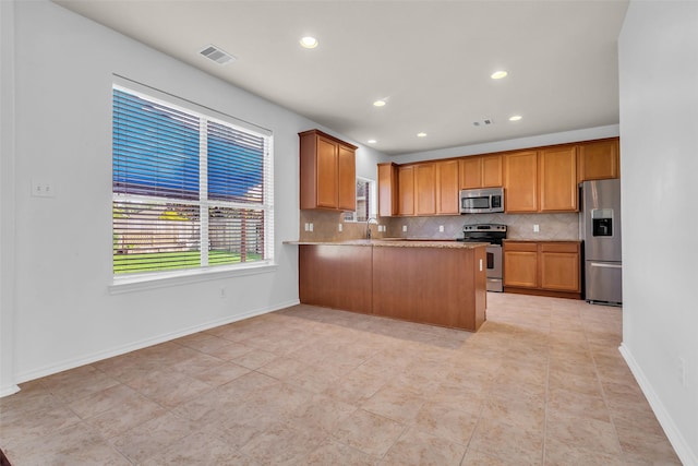 3502 Avalon Spring Ln, Spring, TX 77386 - kitchen with appliances with stainless steel finishes, tasteful backsplash, healthy amount of natural light, brown cabinetry, and recessed lighting