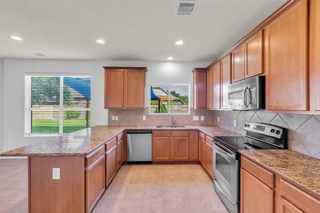 3502 Avalon Spring Ln, Spring, TX 77386 - kitchen featuring appliances with stainless steel finishes, a peninsula, light stone counters, backsplash, and recessed lighting