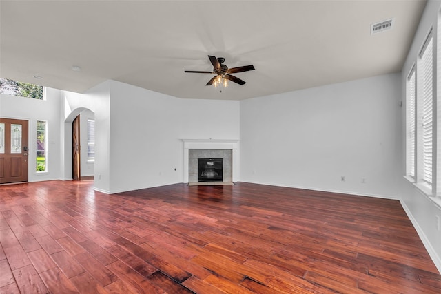3502 Avalon Spring Ln, Spring, TX 77386 - unfurnished living room with ceiling fan, arched walkways, wood finished floors, and a fireplace
