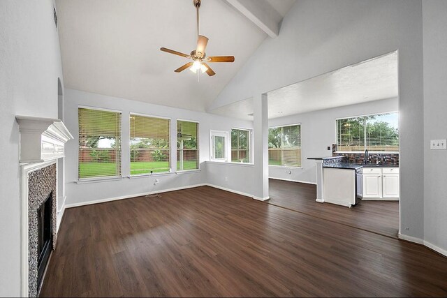 1123 Woodley Bnd, Sugar Land, TX 77479 - unfurnished living room featuring ceiling fan, beam ceiling, a tile fireplace, dark wood finished floors, and high vaulted ceiling