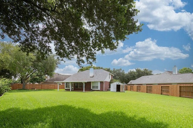 1123 Woodley Bnd, Sugar Land, TX 77479 - rear view of property with a storage shed, a fenced backyard, a chimney, and brick siding