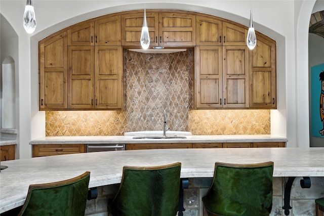 701 W Friar Tuck Ln, Houston, TX 77024 - kitchen featuring light countertops, pendant lighting, brown cabinets, and a breakfast bar