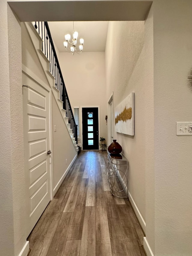15814 Weston Ridge Dr, Humble, TX 77346 - foyer with wood-type flooring, a chandelier, stairs, a high ceiling, and a textured wall