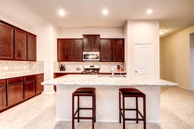 12223 Antilles Ln, Conroe, TX 77304 - kitchen with a breakfast bar, appliances with stainless steel finishes, a center island with sink, backsplash, and recessed lighting