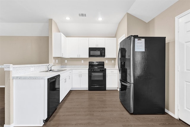 638 E Fairway Lake Dr, Alvin, TX 77511 - kitchen featuring black appliances, lofted ceiling, white cabinets, light countertops, and dark wood-type flooring
