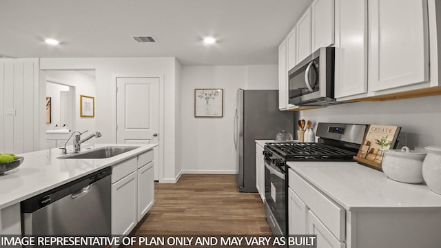 23748 Patchouli Terrace Dr, Splendora, TX 77372 - kitchen featuring appliances with stainless steel finishes, dark wood-style floors, white cabinetry, light countertops, and recessed lighting