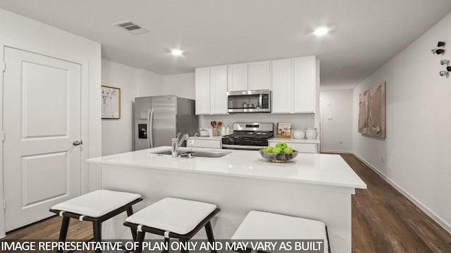 23748 Patchouli Terrace Dr, Splendora, TX 77372 - kitchen with appliances with stainless steel finishes, white cabinets, dark wood-style flooring, light countertops, and a center island with sink